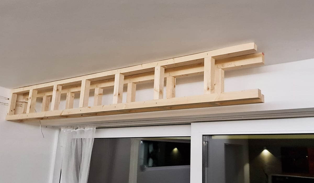 - LedStore Puinen kattohylly integroidulla LED-valaistuksella valaisee tilan liukuvan lasioven yläpuolella, joka on valmistettu vaaleasta keskeneräisestä puusta.