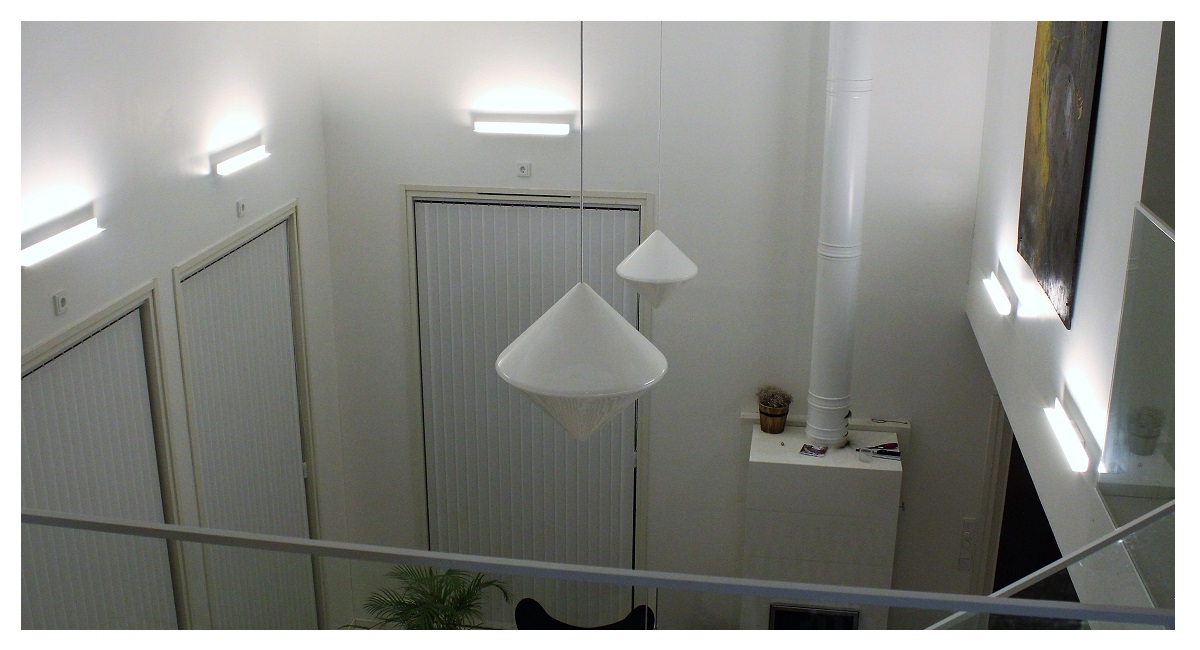 Vägglampor i ett högt vardagsrum