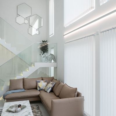 Modernt vardagsrum med LED-belysning, beige soffa, dekorativa statyer i elfenben, geometriska speglar, soffbord i marmor och vita vertikala gardiner.