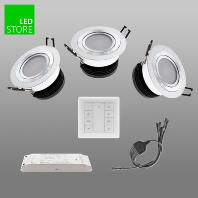 Tre vita infällda LED-lampor med styrenhet, adapter och kabel på en grå bakgrund. LED Store-logotypen i det övre vänstra hörnet. Energieffektiv belysningslösning.