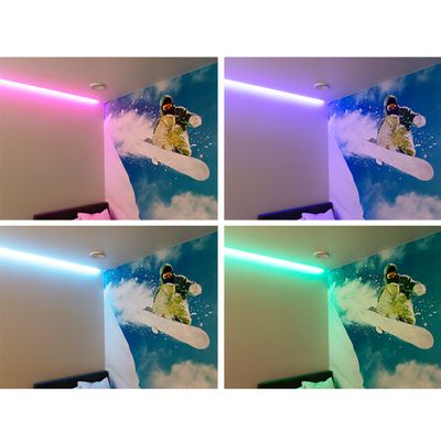 Alternativ text: rumshörna med starka LED-lampor i rosa, lila, blått och grönt som lyser upp en snowboardåkare på en snöig bergsbakgrund.
