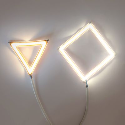 Närbild av ett LED-ljusband med röda och svarta kablar mot en vit bakgrund.