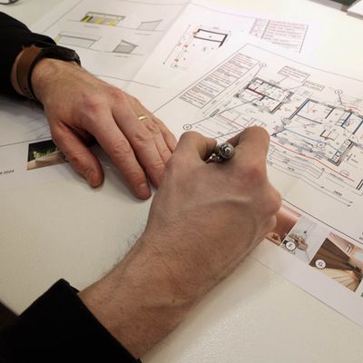 Ljusdesignanalys av arkitektoniska planritningar i blyerts, på ett skrivbord, i ett interiört belysningssammanhang.