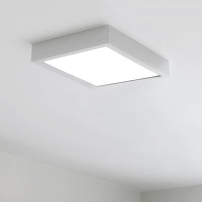 En kvadratisk taklampa med starkt vitt ljus i ett minimalistiskt vitmålat rum. Modern LED-belysning accentuerar alla utrymmen.