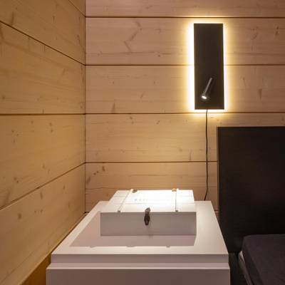 Modern rektangulär svart vägglampa med justerbar spotlight, perfekt för moderna interiörer och energieffektiva LED-belysningslösningar.