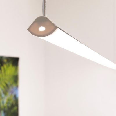 Modern LED-taklampa med elegant vit design, hängande i rummet; grönt konstverk delvis synligt på väggen. Perfekt för stilfull belysning i hemmet.