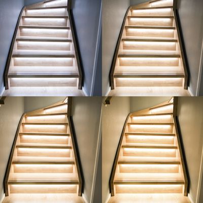 Modern trätrappa med inbyggd LED-belysning. Fyra hörn visar upp den snygga, upplysta trappan för en snygg och säker hemdesign.