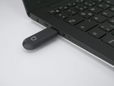 USB-minne anslutet till en bärbar dator på en vit bakgrund, symboliserar uppkoppling och teknik i moderna LED-belysningslösningar.