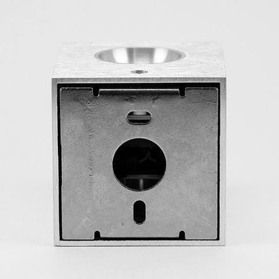 Modern kubformad LED-armatur i metall med en cirkulär frontöppning mot en ren bakgrund. Perfekt för stilrena belysningslösningar.