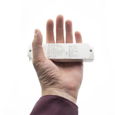 Närbild av en hand som håller i en rektangulär LED-belysningsprodukt med tekniska specifikationer synliga. Visar tekniska detaljer för energieffektiv belysning.