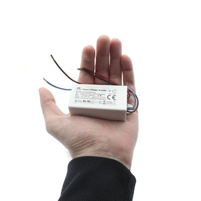 Liten rektangulär LED-strömförsörjning med synliga kablar, vit bakgrund. Energieffektiv komponent för belysningslösning.