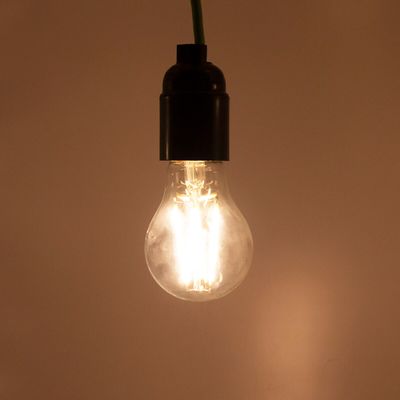 En sladdhängd LED-lampa avger ett mjukt sken mot en neutral bakgrund och visar upp moderna energieffektiva belysningslösningar.