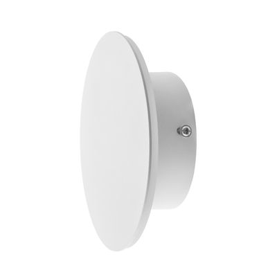Vit rund vägglampa med plan cirkulär yta och cylindrisk bas, snedställd. Idealisk för moderna interiörer och ger stämning med LED-belysning.