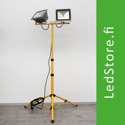 Dubbelhövdad gul LED-arbetslampa med stativ, vit bakgrund. Grön text "LedStore.fi" bredvid. Idealisk för professionell belysning och belysning i hemmet.