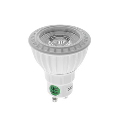 LED-lampa med GU10-sockel och "QC PASS"-stick, vertikalt monterad mot en vit bakgrund för LED-belysningsrörelse.