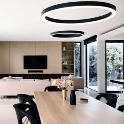 Moderna LED-taklampor lyser upp ett rymligt vardagsrum/matsal med träbord, beige soffa, TV på väggen, stora fönster och minimalistisk inredning.