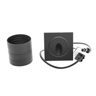 Kvadratisk infälld taklampa med cylindrisk adapter och kablage på en slät vit sockel - modern LED-belysning.