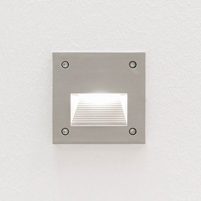 Den infällda kvadratiska vägglampan lyser upp en vit texturerad vägg med ett mjukt sken för en modern LED-belysningsestetik.