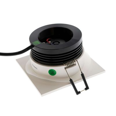 Svartvit fyrkantig LED-downlight med fjäderklämma och svart kabel på en vit yta - den perfekta moderna belysningslösningen.