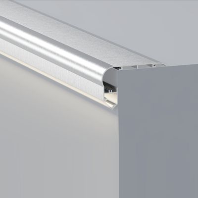 En modern silverfärgad gardinstång med en elegant rundad kant på en ljusgrå vägg, som framhäver modern design för snygga belysningslösningar i hemmet.