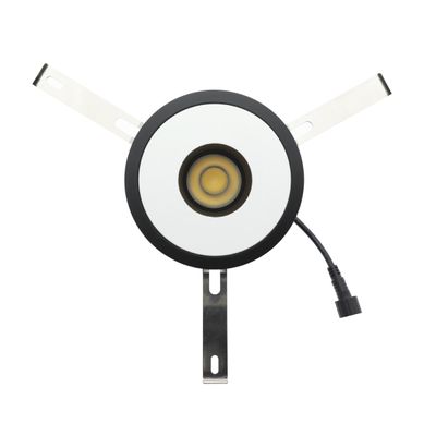 Rund infälld LED-taklampa, svart klädsel, vit kärna, metallarmar, nätsladd med kontakt; perfekt för moderna belysningslösningar.