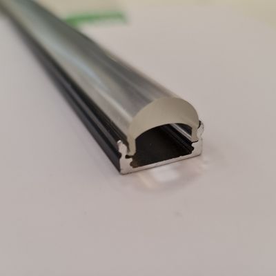 Närbild av en LED-profil i aluminium med rundad kupa mot en vit bakgrund, elegant design och modern belysningslösning.