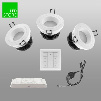 Tre vita infällda LED-lampor med styrenhet, adapter och kabel på en grå bakgrund. LED Store-logotypen i det övre vänstra hörnet. Energieffektiv belysningslösning.