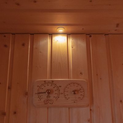 Väggdisplay i träpanel med LED-upplyst liten lampa och träplatta med inbyggd termometer och hygrometer för en modern hematmosfär.
