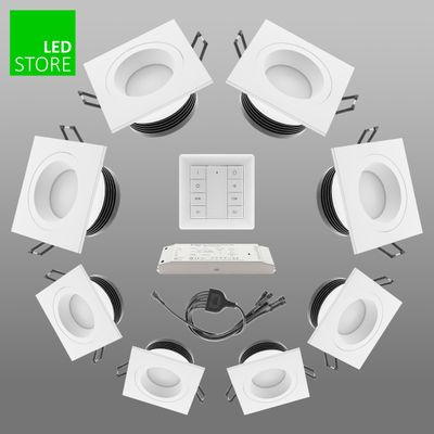 Åtta vita kvadratiska LED-downlights i en cirkulär konfiguration med central kontrollpanel och kablar, en idealisk energieffektiv belysningslösning.