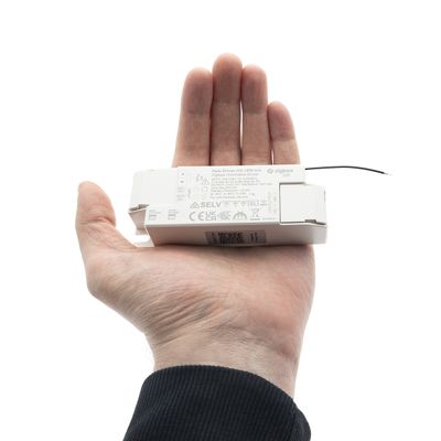 En person håller i en LED-ljuskontroll som visar storlek och funktion och visar upp modern belysningsteknik i en butik.