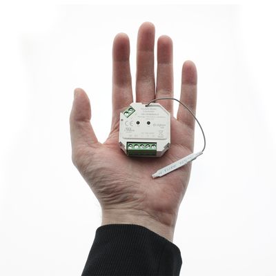 "En person håller i en LED-kontroller med kablar och kontakter mot en vit bakgrund som visar elektroniska komponenter från en LED-belysningsbutik.