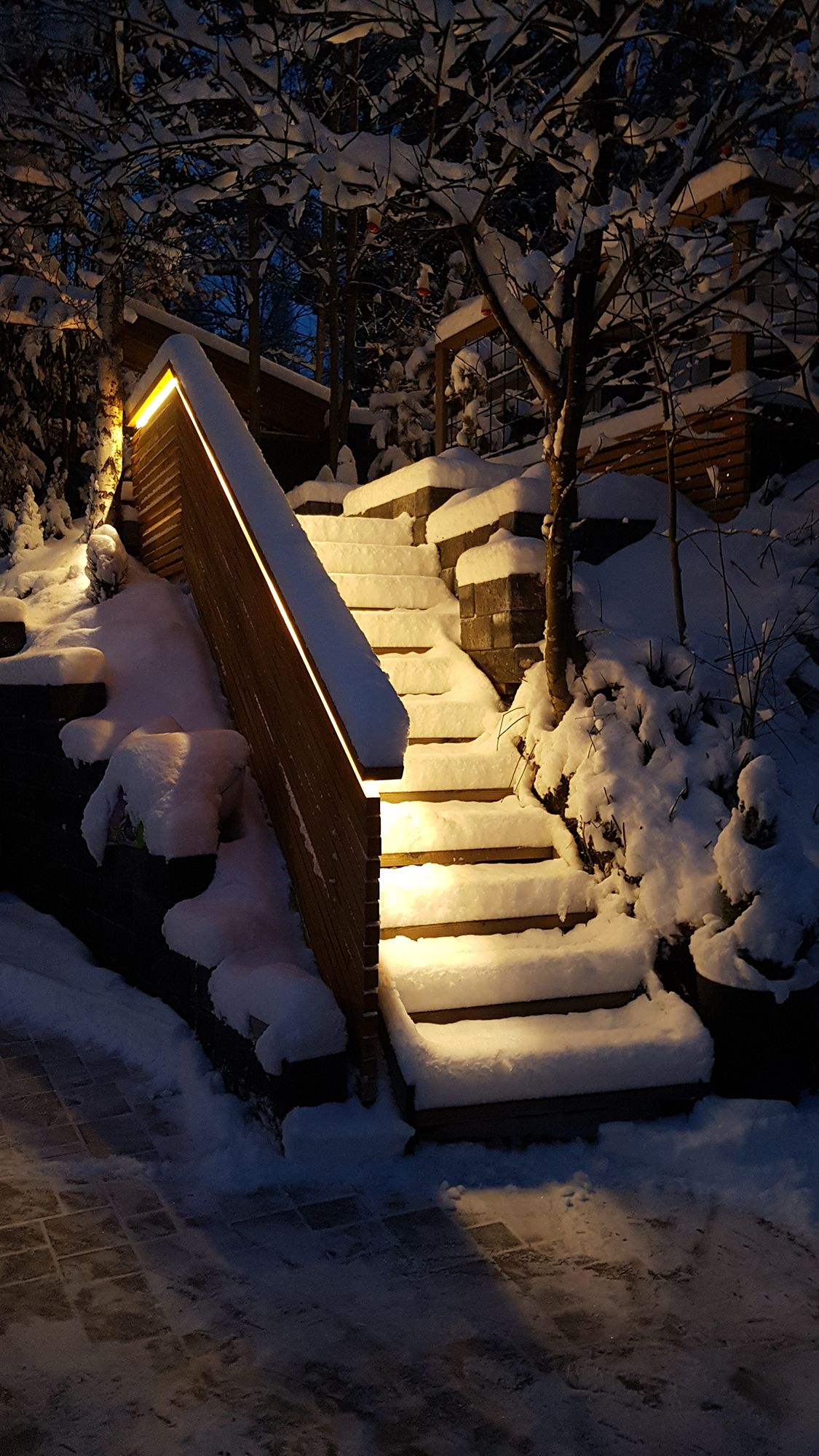 Utvändig trappbelysning implementerad med LED-list på balustraden. Ljuset är atmosfäriskt indirekt ljus, LED-listen som används är en varm 3000K 7,2W/m-list. Ledstore.fi