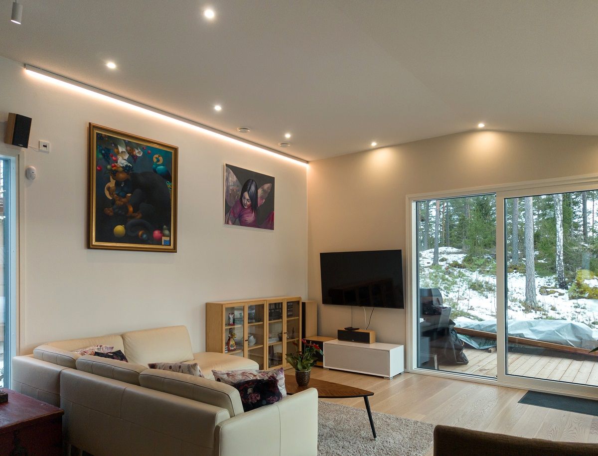 Vardagsrum med flera spotlights och en vägg med LED-listbelysning.