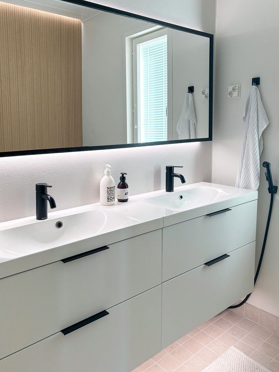 En stor ljus spegel lyser upp ett rum genom att reflektera ljuset genom väggarna. LED-listen under skåpet gör det enkelt att gå runt och städa upp, och ger en mjuk atmosfär. © LedStore.fi