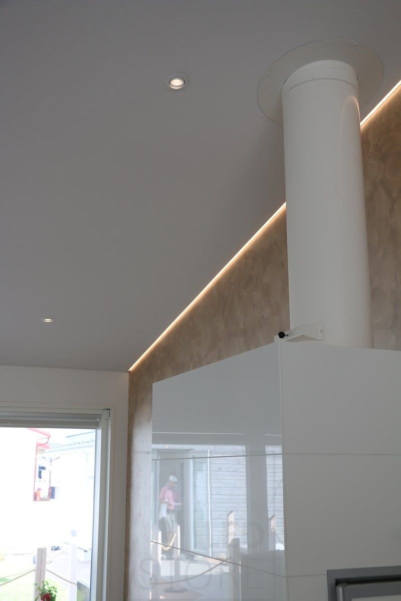 Bostadsmässan 2018: led-profil på ett sluttande, stigande tak, i gränssnittet mellan vägg och tak, bakom eldstaden. Ledstore.fi