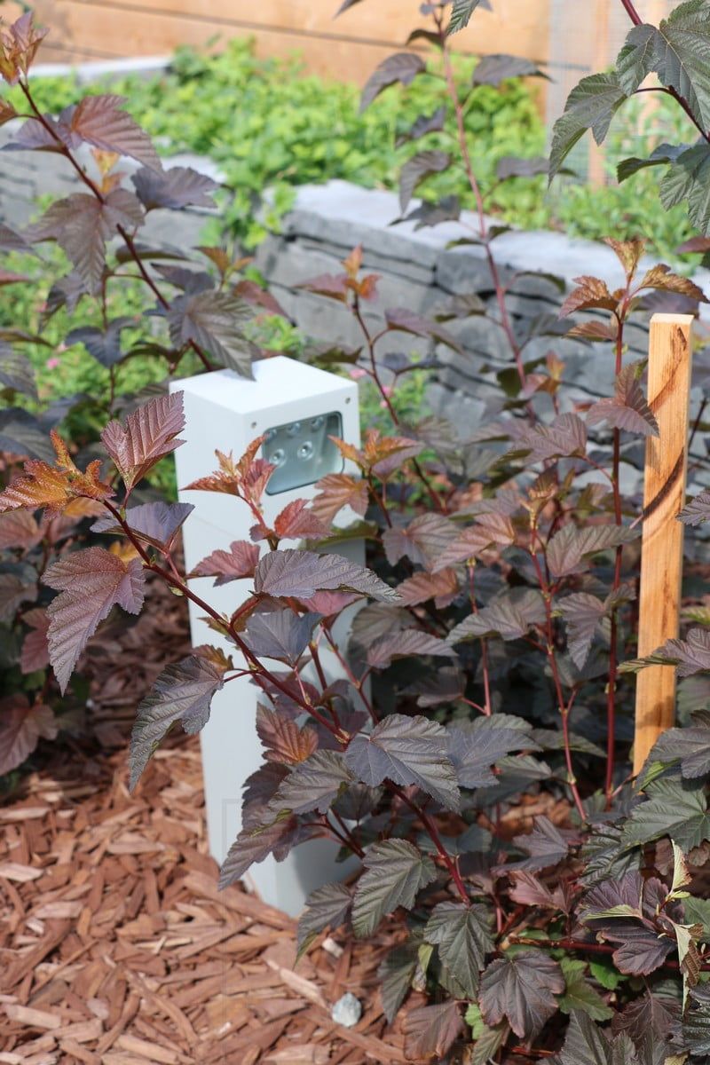 Bostadsmässan 2018: närbild av kubisk pelare i en blomsterrabatt. Ledstore.fi