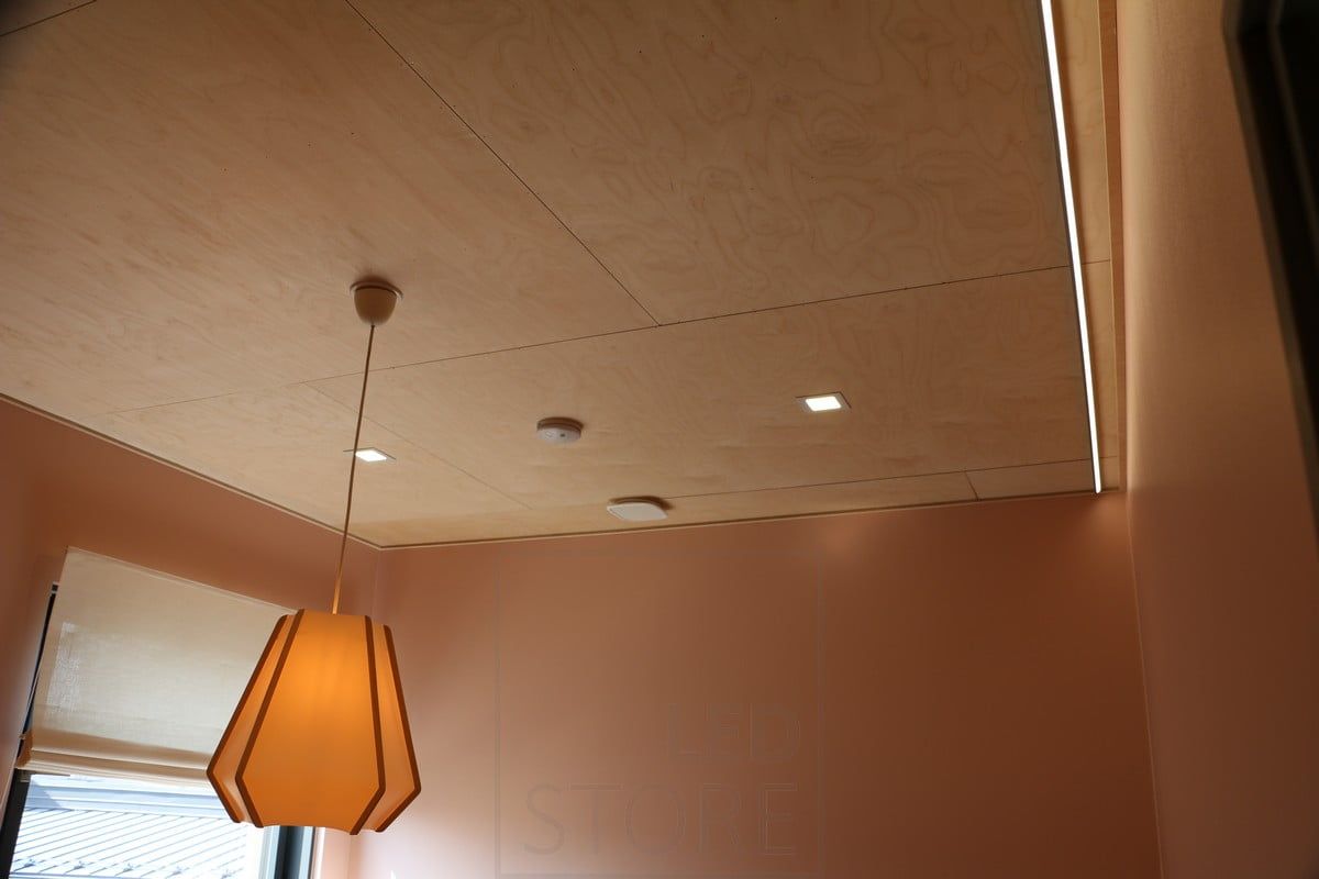 Bostadsmässa 2019: Små panelarmaturer på ett plywoodtak. Ledlist som belyser väggen för indirekt ljus. Ledstore.fi