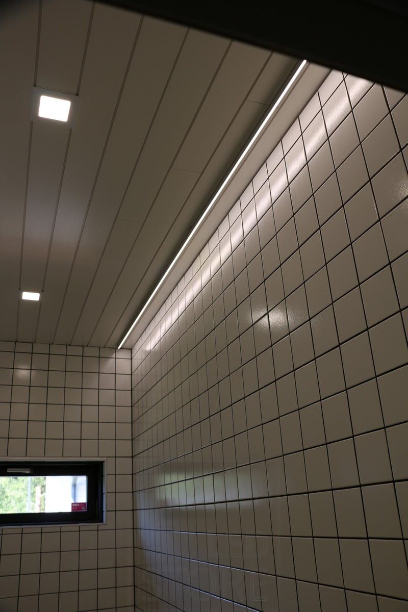 Bostadsmässan 2019: Ledlist i taket intill väggen, ljuset reflekteras från det blanka kaklet. Ledstore.fi
