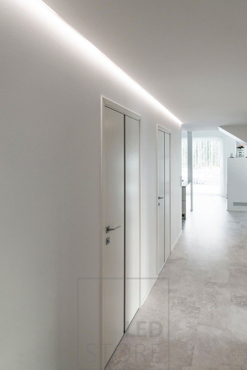 En korridor vackert upplyst med indirekt ljus. Ledlist i aluminiumprofil monterad i spåret mellan tak och vägg. Ledstore.fi