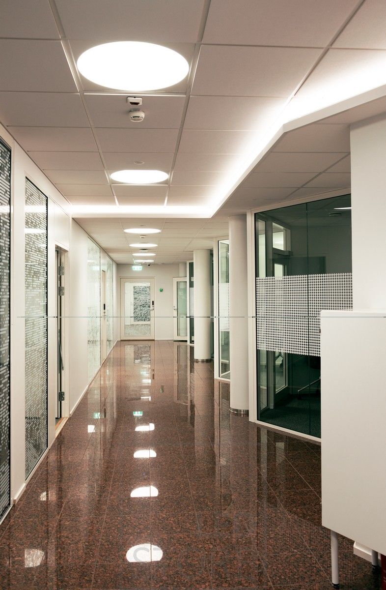 Ledlist monterad på downlight i en korridor som skapar stämningsfullt indirekt ljus genom taket. Allmänbelysning med infällda Plafondi-armaturer.