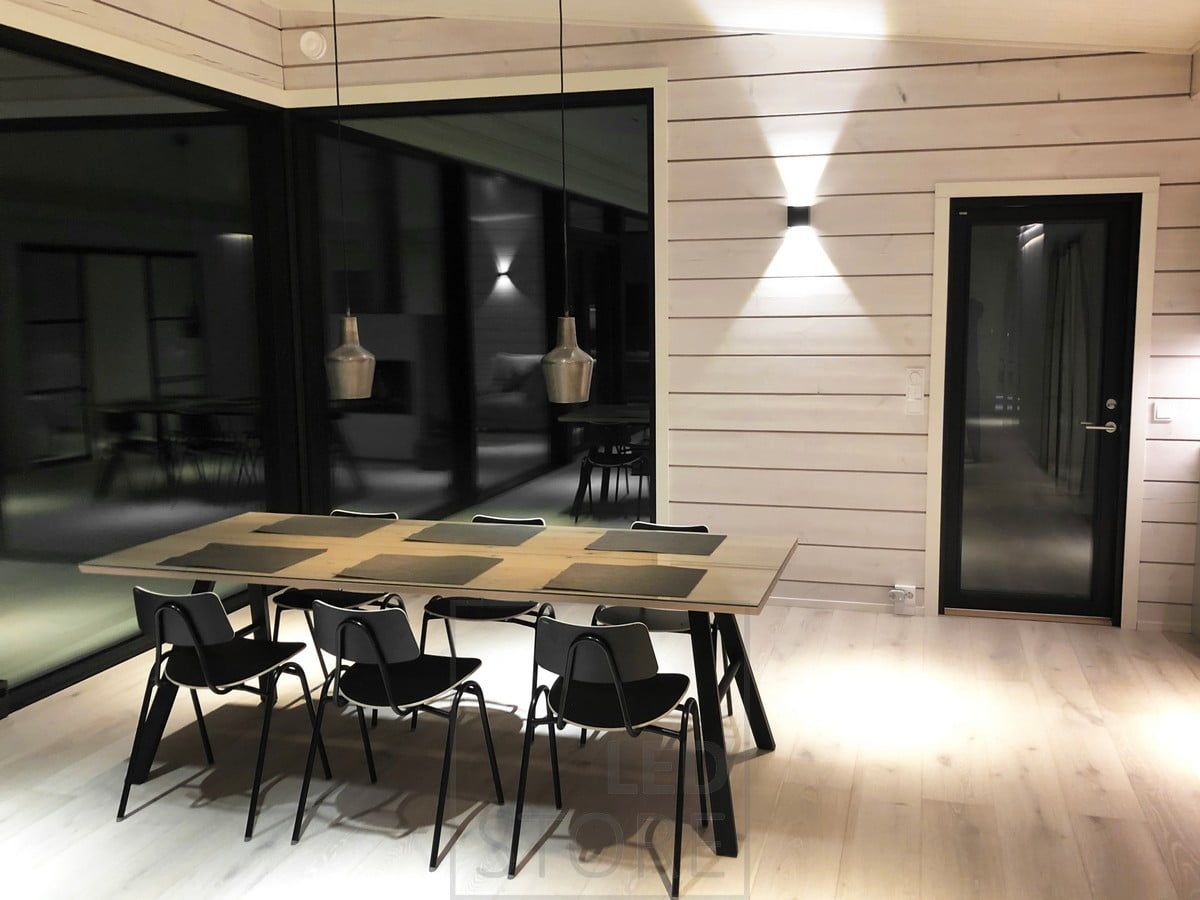 Svart led-vägglampa FUNK skapar indirekt stämningsbelysning på väggen i matplatsen. Ledstore.fi