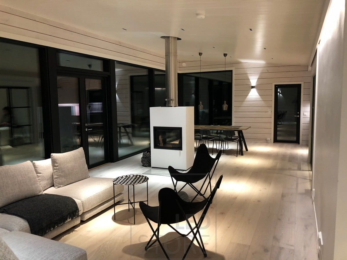 Svart FUNK vägglampa i vardagsrummet som stämningsbelysning. Lampan är minimalistisk, modern och perfekt för skandinaviska inredningar. Ledstore.fi