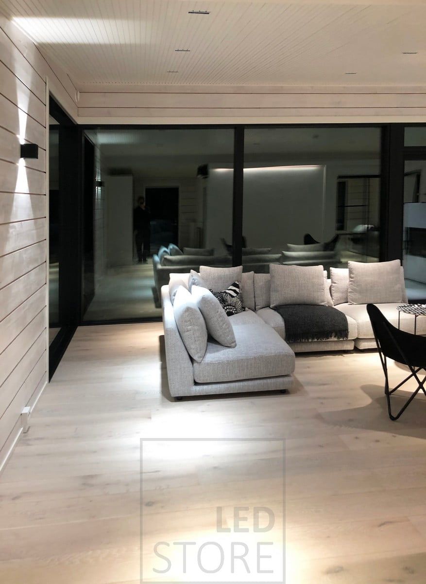 FUNK led-vägglampa bakom soffan i vardagsrummet. Ljuset skapar även indirekt ljus genom taket. Ledstore.fi