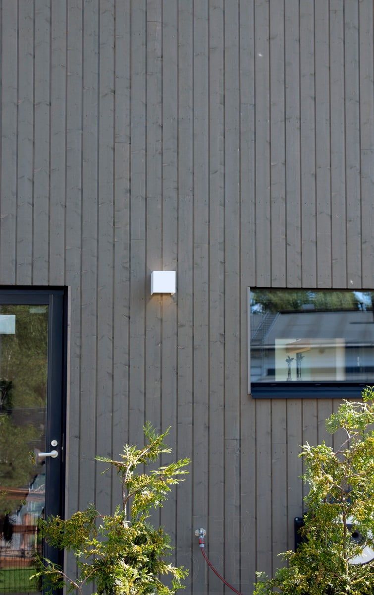 Vit led-vägglampa FUNK utomhus som belyser en fasad. Ledstore.fi