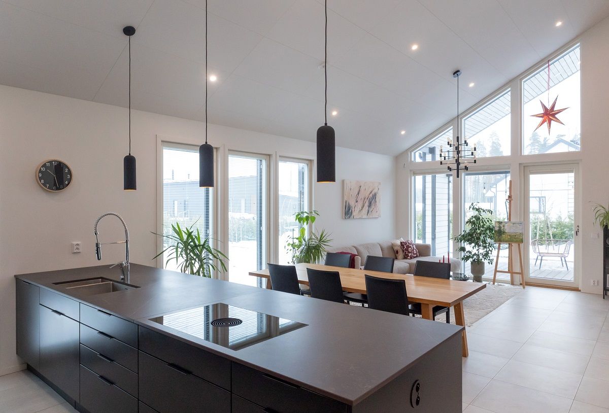 Flera led-spotlights i taket i vardagsrummet, plus kundens egna pendellampor.