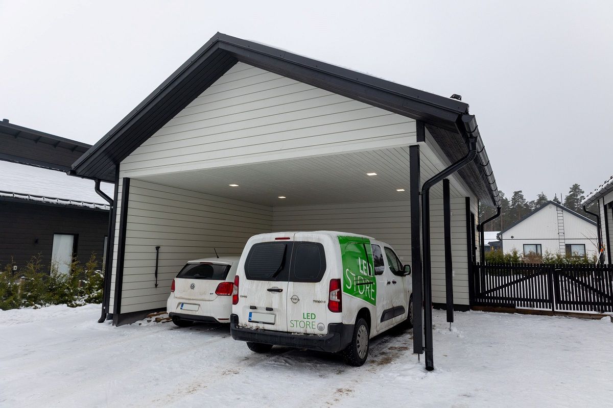 Carport upplyst av fyra små panellampor.