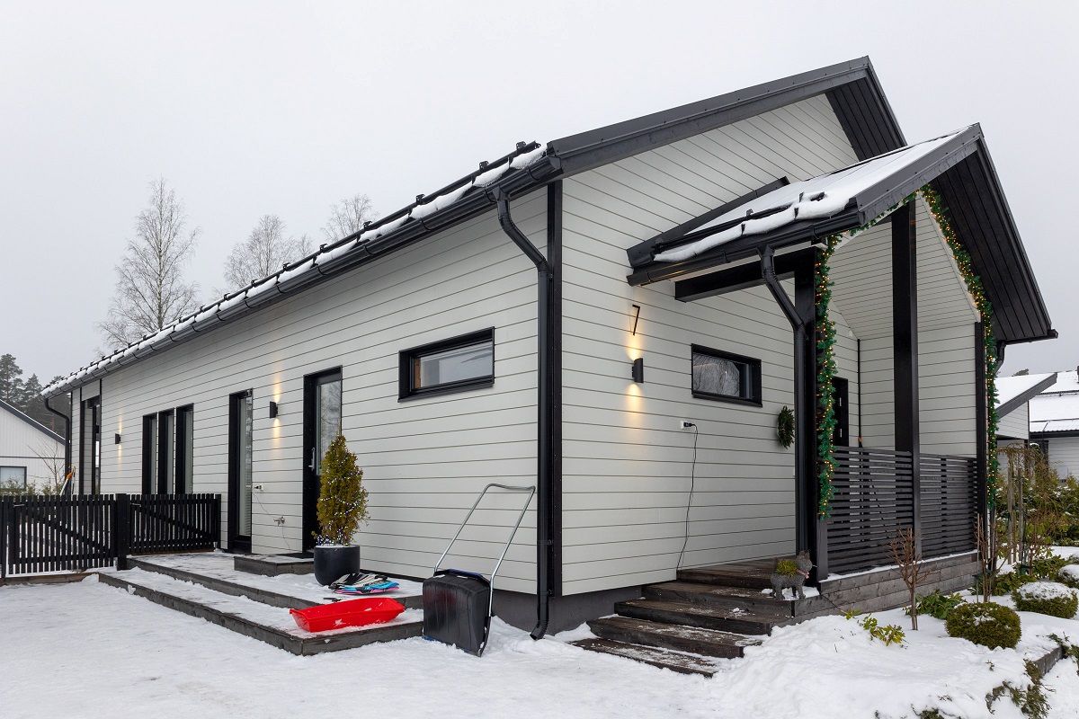 Husets fasad är upplyst med VIISTO2 vägglampor.