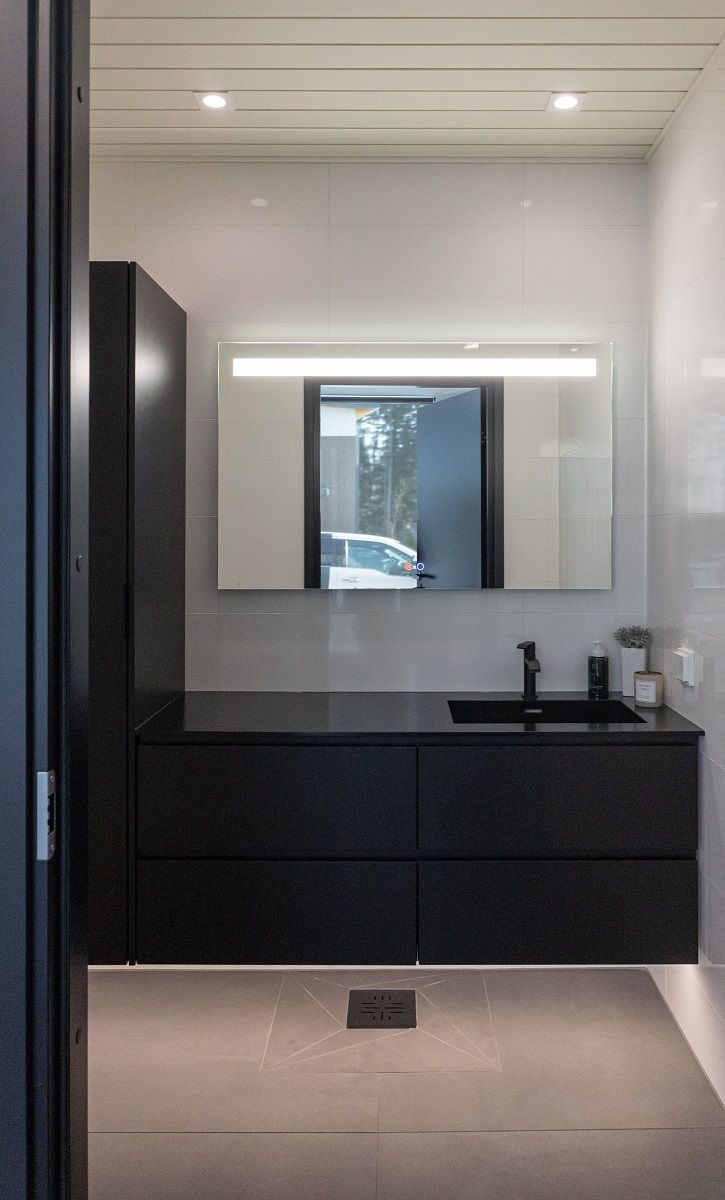 Badrum med LED-list under skåpen för indirekt ljus, spegellampan SEELIA och två LED-downlights SQ023 i taket.