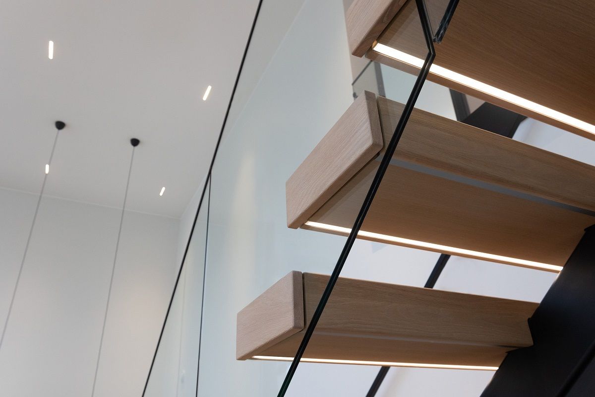 Under trappsteget, infälld led-list i profil. LINJA10 led spots i bakgrunden på taket.