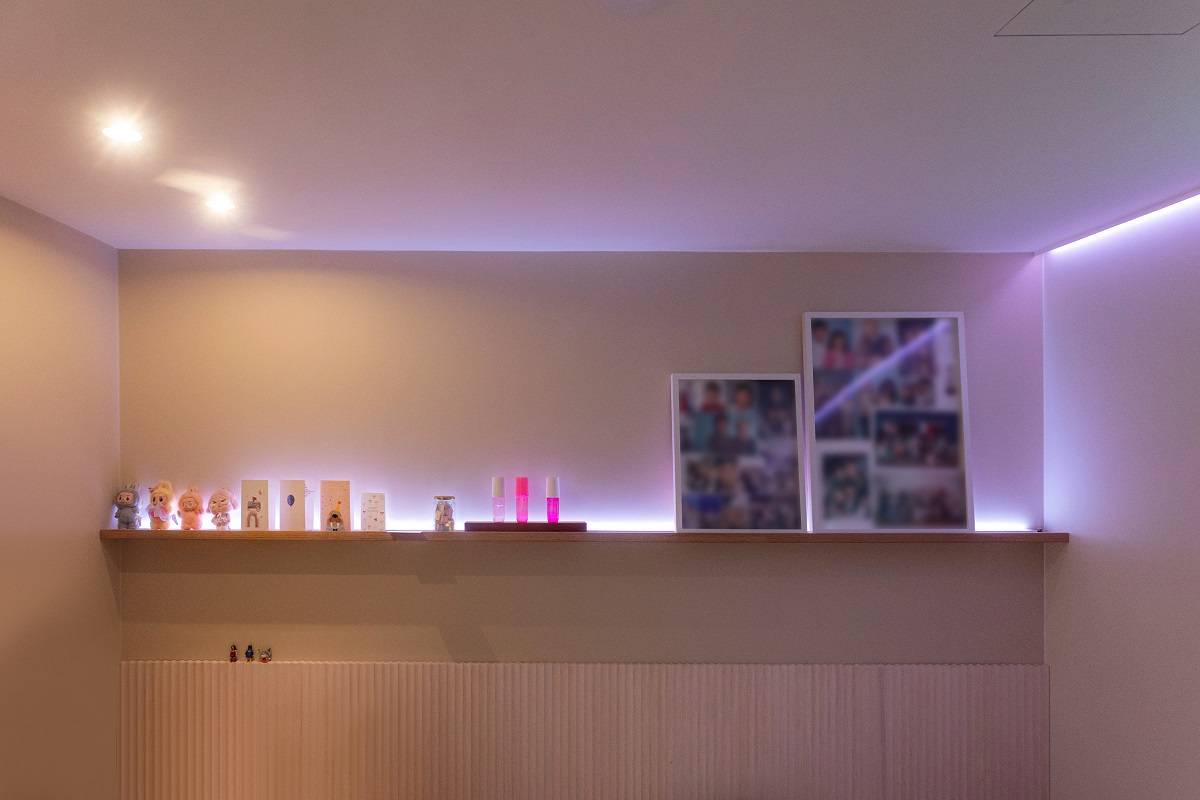 En LED-remsa som avger lila ljus löper runt i rummet, och i taket finns dessutom två spotlights.